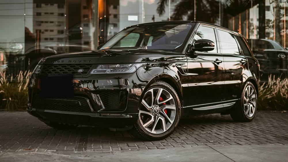 SUV blindado de luxo estacionado em frente a uma fachada envidraçada
